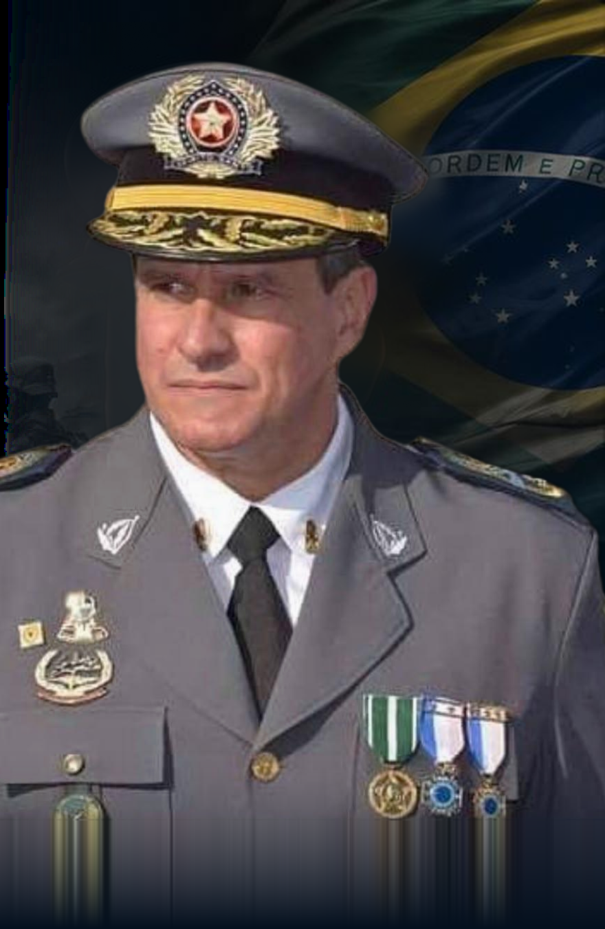 Coronel Alexandre Ofranti Ramalho fardado, diante da bandeira do Brasil